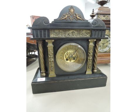 An early 20th century black slate mantel clock having classical metal applique decoration and striking movement