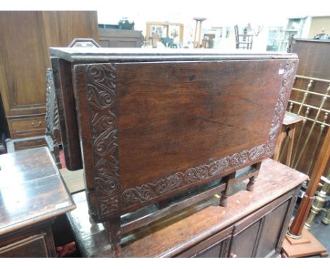 A late 19th century oak dining table having foliate border rectangular drop leaf top, on turned gate legs