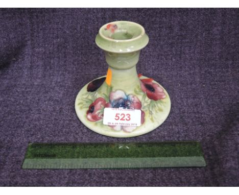 A Moorcroft candlestick of squat design having pattern on light green ground
