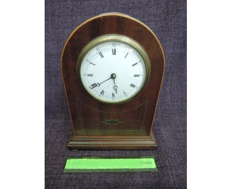 An Edwardian mahogany arch cased mantel clock having brass line inlay decoration and white enamel face
