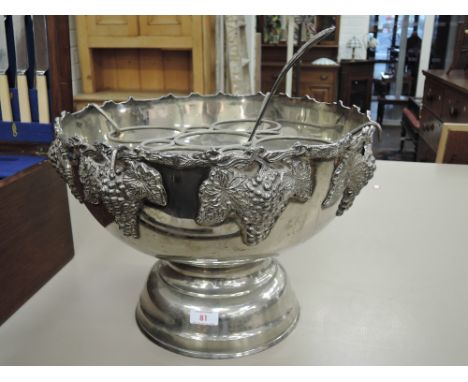 A large silver plated Indian punch bowl having grape vine decoration and matching ladle and attachment to convert into ice bu