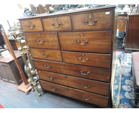 An early 19th century oak tall chest of three frieze, four graduated and three long drawers, on bracket feet
