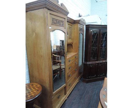 A late Victorian ash,aesthetic style bedroom suite comprising wardrobe having double scroll top with central carved cupboard 