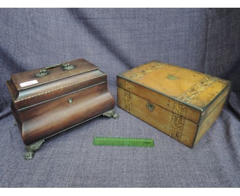 An early 19th century mahogany tea caddy of bombe shape having chevron inlay decoration and cast animalistic feet and a 19th 