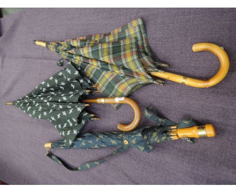 Two walking stick style umbrellas by Jaeger having the Jaeger emblem to navy ground and tartan design and another Jaeger umbr