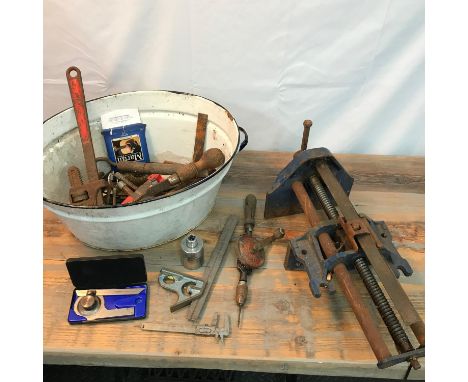 An old enamelled two handle wash basin containing a quantity of old tools to include Measuring gauges, Large Record Vice No52