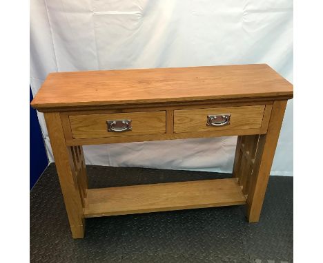 A Contemporary solid light oak console table designed with two drawers and under shelf. Measures 77x100x32cm 