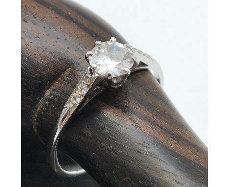 An Antique ladies 14ct white gold ring set with large single diamond off set by three diamonds to each shoulder. Large diamon