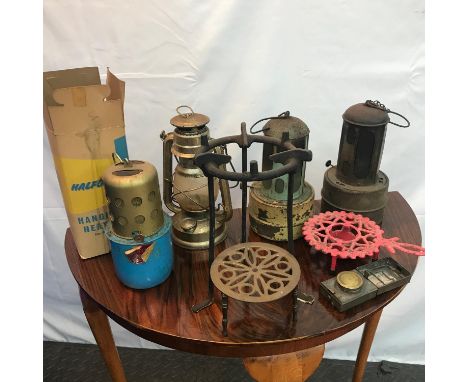 A Collection of hanging heat lamps, storm lamp, trivet stands and small pocket paraffin lamp. 