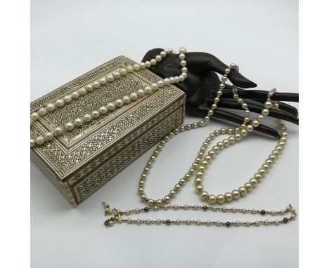 A Lot of four vintage pearl necklaces with silver clasps. Together with a vintage Mosaic jewel box. 