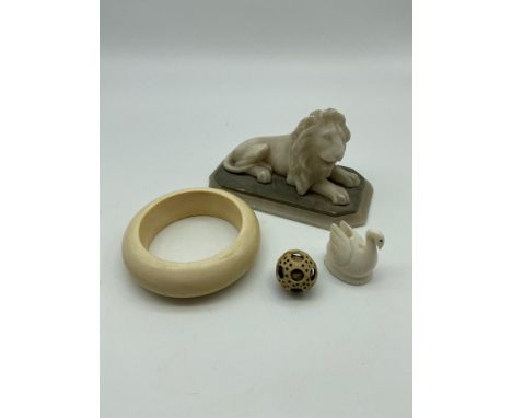 A 19th/20th century hand carved marble lion sculpture [13cm in length], 19th century ivory bangle, 19th century carved puzzle