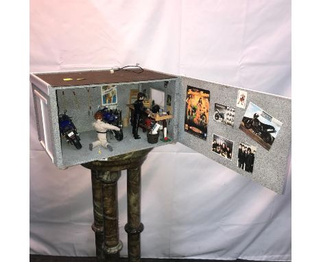 A Mock up of a street motorbike garage detailing props, posters, motorbikes, figures and tool bench with tools. Has electrics