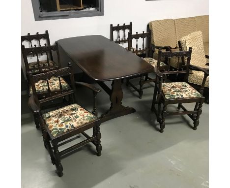 A vintage Ercol elm wood dining table with four chairs and two carvers. Very good condition. Table measures 72x155x78cm 