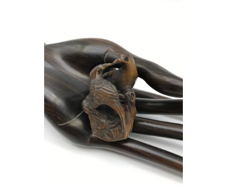 A Japanese hand carved netsuke figure of two love birds perched on a stump. Both detailed with black bead eyes and signed by 
