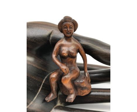 A Japanese hand carved netsuke figure of a nude geisha sat on a rock. Signed tot he base by the artist. 