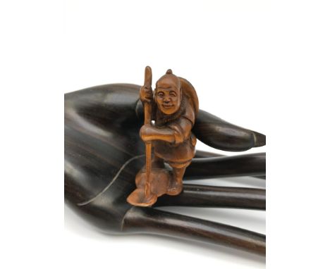 A Japanese hand carved netsuke figure of a farmer. Signed by the artist. 