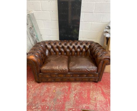 A Chesterfield Rustic brown leather two seat sofa. 