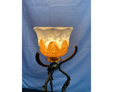 An art Nouveau cast metal base free standing light, set with an ornate painted shade. Measures 81.5cm in height. In a working