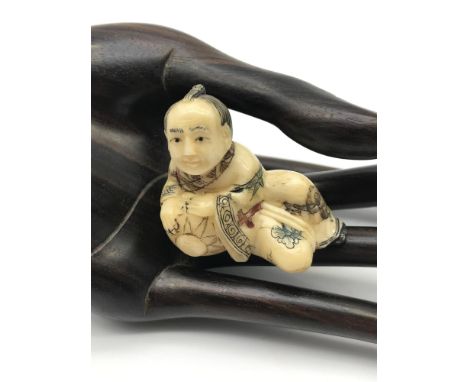 A Japanese hand carved netsuke figure of a musician playing a drum. Highly detailed and signed to the base by the artist. 