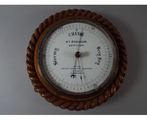 An Edwardian Circular Aneroid Barometer with Rope Border and Enamelled Dial Inscribed HY Robinson. Optician To The Salop Eye 