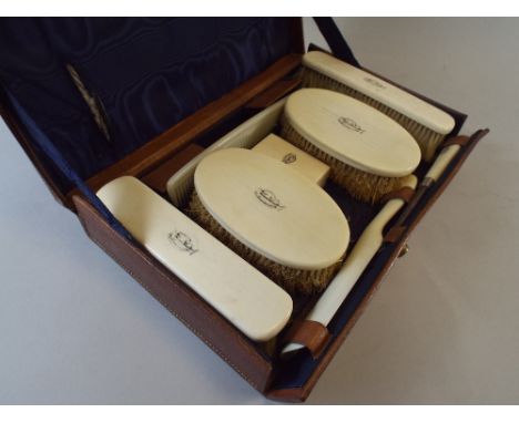 An Early 20th Century Leather Travelling Case with Monogrammed Ivory Mounted Brushes, Box, Button Hook and Shoe Horn, 30x19x6