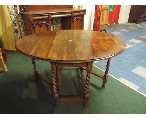 An Oak Oval Topped Drop Leaf Gate Leg Table with Barley Twist Supports. 