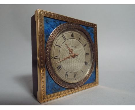 A Pretty 18 Carat Gold and Blue Enamelled Travelling Clock by Cartier having Silvered Dial with Roman Numerals and Engine Tur