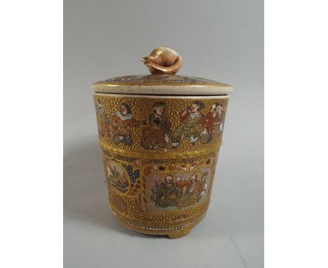A Japanese Satsuma Lidded Pot Decorated with Figural Cartouches, a Band of Figures and Gilt Highlights. Shell Finial. 3 Feet.