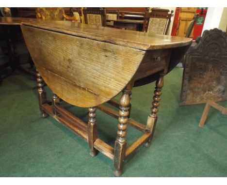A Period Oak Drop Leaf Gate Legged Table with Bobbin Supports and End Drawer. 