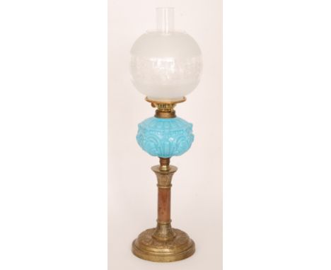 A Victorian brass oil lamp and shade with moulded pale blue scroll reservoir on cylindrical column and leaf embossed base, he