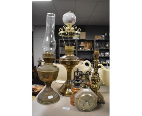 Two brass bodied oil burning lamps, a coffee mill and a brass lamp base