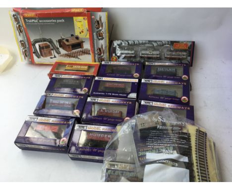 A collection of boxed Hornby and Dapol 00 scale model railway rolling stock and trackside accessories