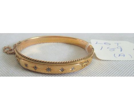 A 15ct gold and diamond bangle. Condition Report: Has several dents to back side of bangle.  Marked 15ct to inner clasp.  6.5