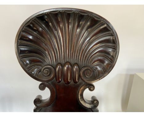A pair of Regency mahogany carved shell back hall chairs attributed to Gillows
The shaped backs above bowed seats and moulded
