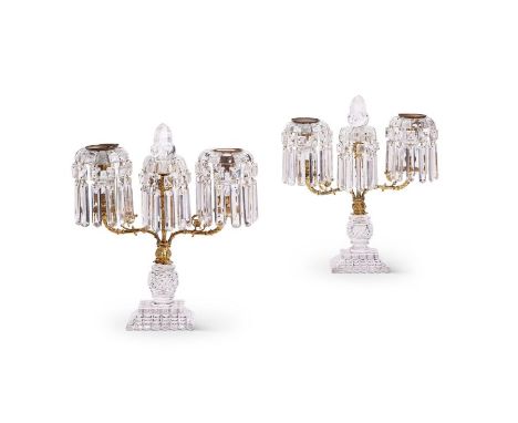 A pair of Regency cut glass lustre twin-light candelabra
With gilt brass nozzles with square and rectangular drops, with cent