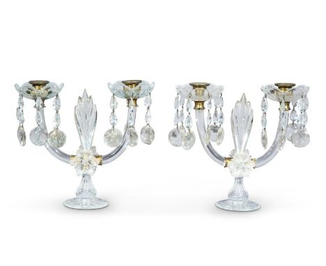 A pair of George IV cut-glass lustre twin-light candelabra With gilt brass sconces and foliate drip-pans, with beaded drops a