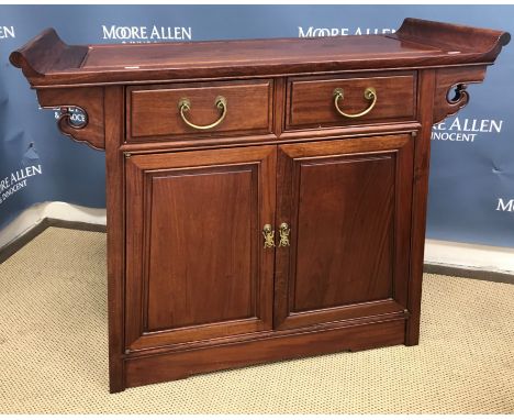 A modern Chinese cherry wood side cabinet, the scrollwork decorated top over two drawers and two panelled cupboard doors encl