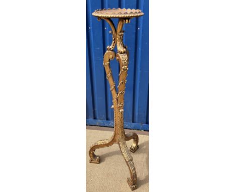 A carved giltwood and gesso framed torchere in the Continental Rococo taste, the circular top with gadrooned edge on a scroll
