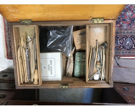 An artist's box and contents of various palette knives, charcoal and other tools and a canvas satchel containing artist's boa