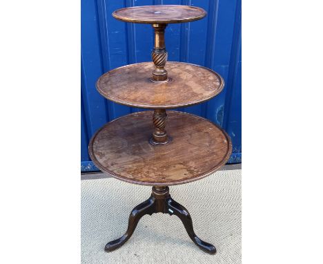 A late George III mahogany three tier dumb waiter, the graduated dished circular tiers interspersed by wrythen carved and tur