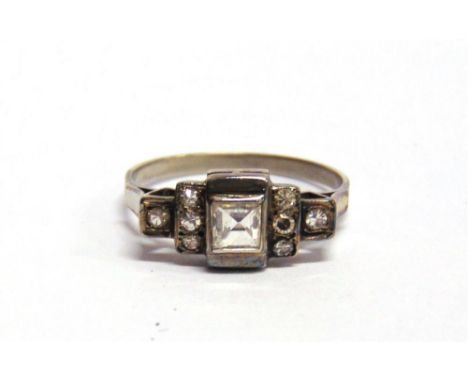 A DIAMOND RING the central square cut diamond of approximately 0.4 carats, flanked either side by single cuts, finger size P 
