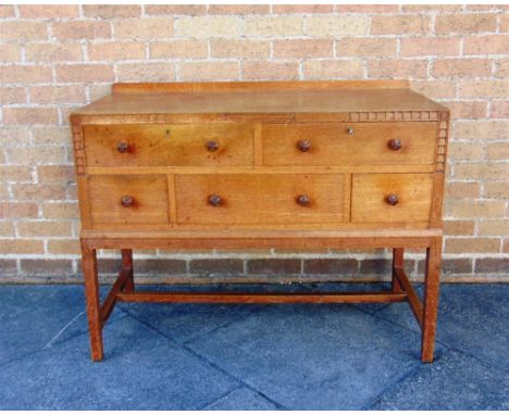 A COTSWOLD SCHOOL ARTS AND CRAFTS LIGHT OAK SIDEBOARD,  fitted with an arrangement of five drawers, the top right drawer baiz