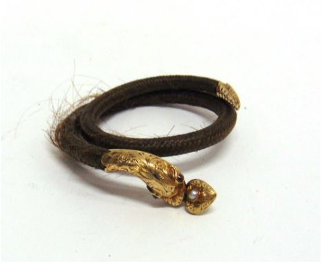 A VICTORIAN HAIR SERPENT BANGLE the head set with garnet eyes, locket back heart drop to its mouth