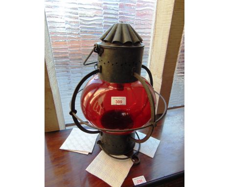 AN EARLY 20TH CENTURY HANGING LANTERN  with metal frame and red glass shade 66cm high 33cm diameter