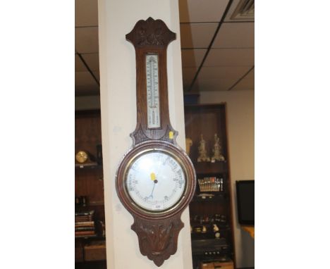 A CARVED OAK BAROMETER 