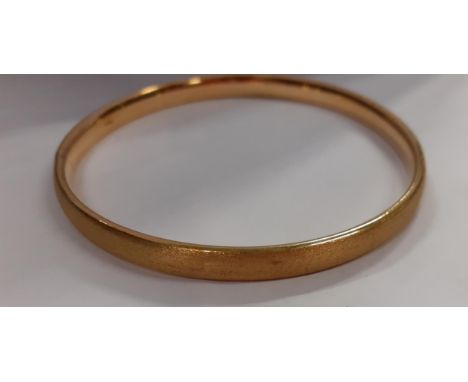 A gold coloured bangle with the initials BV possibly Bottega Venetta, in brushed metal to the exteriorLocation: Cab2 