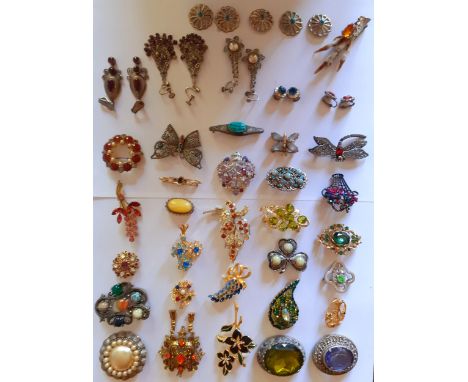 A collection of vintage paste stone brooches to include Scottish examples, a Florenze amethyst coloured and faux opal floral 