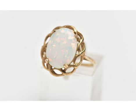 A 9CT GOLD RING, designed with a four claw set, oval synthetic opal cabochon, within an openwork scallop surround, thin polis