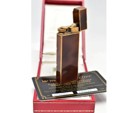 A BOXED 'LES MUST DE CARTIER' LIGHTER, brown laquear gold plated lighter, with signed 'Cartier' fitted case and certificate (