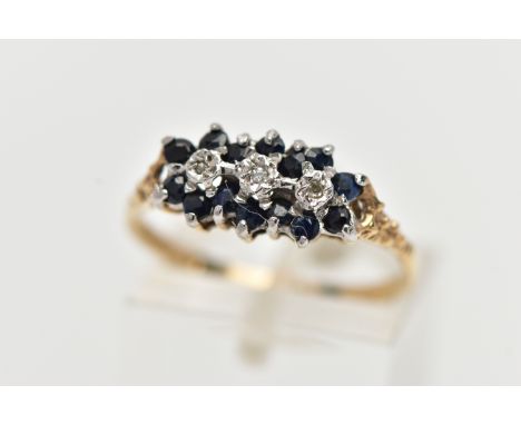 A 9CT YELLOW GOLD DIAMOND AND SAPPHIRE DRESS RING, set with three diamond accents, surrounded by circular cut sapphires, to t